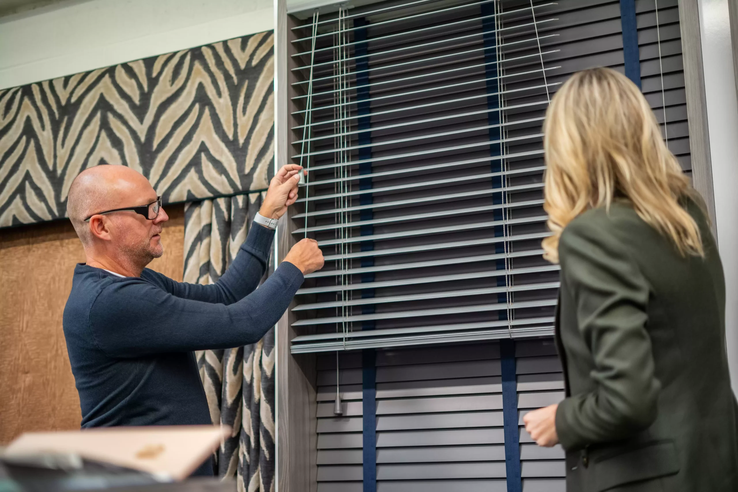 Visitors at Curtain Studio's showroom testing some blinds.