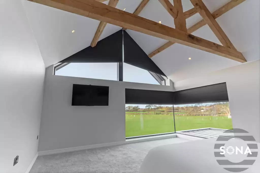 A large, brightly lit room with triangular blinds covering two of the windows.