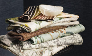 A stack of light-coloured folded fabrics.