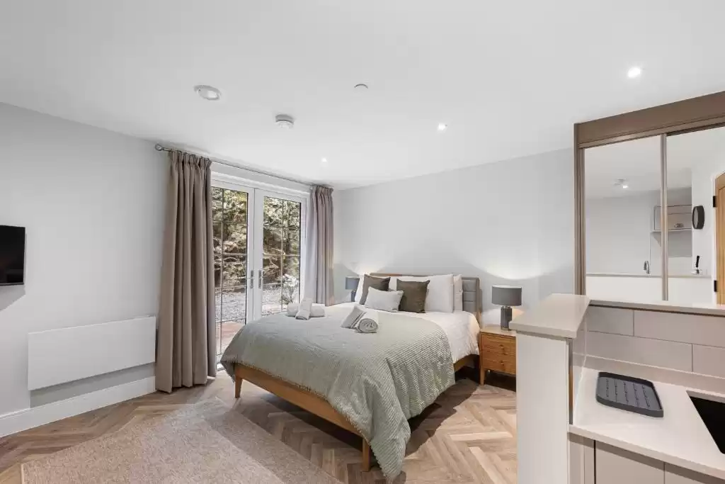 A grey-coloured bedroom showcasing some of Curtain Studio's curtains.